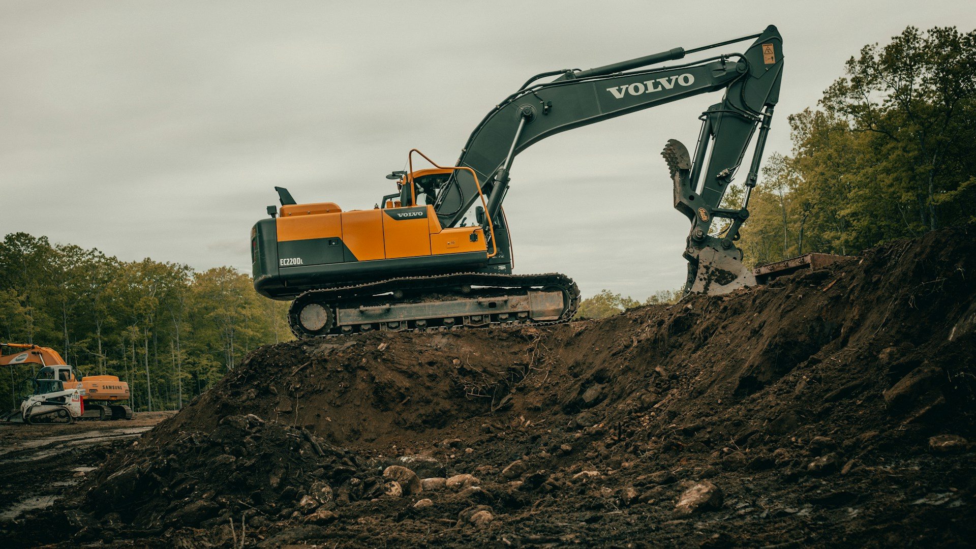 Excavator working on a wooded property site in Vermont